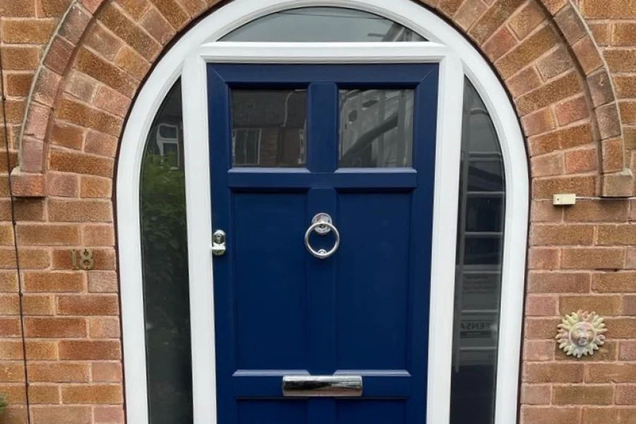 Blue panelled uPVC entrance door with arched glazing in a brick home